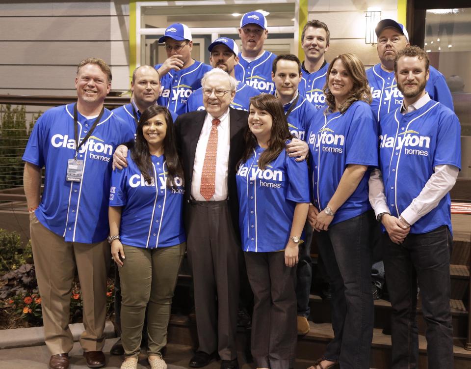 Billionaire investor Warren Buffett poses for a photo with employees of Clayton Homes, a Berkshire Hathaway subsidiary, while touring the exhibition floor in Omaha, Neb., Friday, May 2, 2014, one day before the Berkshire Hathaway annual shareholders meeting Saturday. (AP Photo/Nati Harnik)