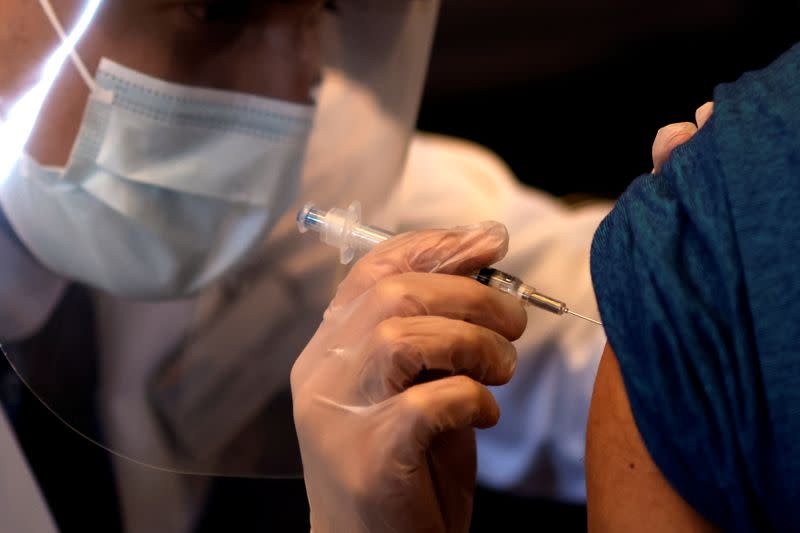 A person receives a dose of the Johnson & Johnson coronavirus disease (COVID-19) vaccine during a visit of U.S. Vice President Kamala Harris to a vaccination center in Chinatown, in Chicago