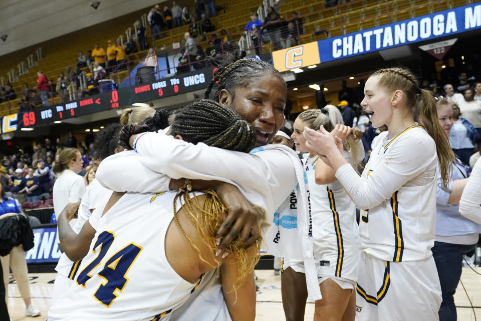 Chattanooga guard Jada Guinn (24) is hugged by Jas Joyner, a graduate assistant and former champion player for Chattanooga after Chattanooga won the NCAA women's college basketball championship game for the Southern Conference tournament over UNC Greensboro, Sunday, March 10, 2024, in Asheville, N.C. (AP Photo/Kathy Kmonicek)