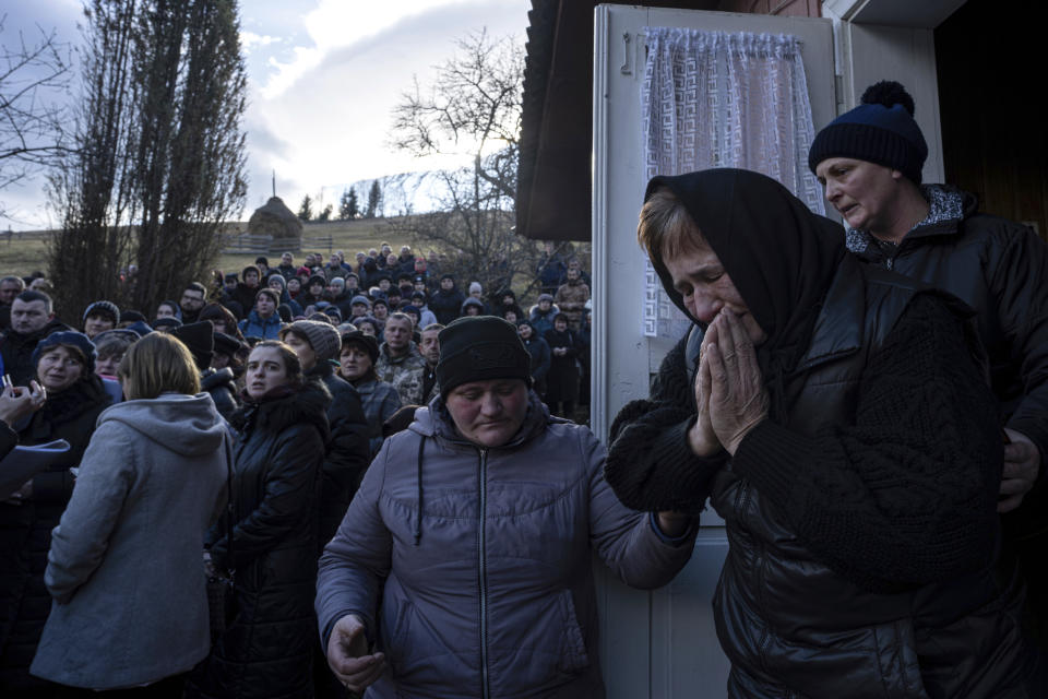 The mother of Ukrainian army officer Vasyl Medviychuk cries during her son's funeral ceremony in the Carpathian mountains in Krasnyk village, Ukraine, Friday, Dec. 29, 2023. (AP Photo/Evgeniy Maloletka)