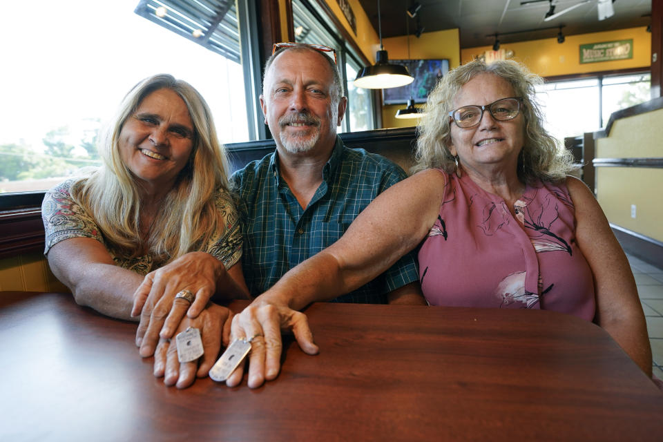 Two days after Debby-Neal Strickland, left, and Jim Strickland, center, were married in November, Debby donated a kidney to Jim's ex-wife Mylaen Merthe, right, as they show off donor/recipient tags they had made during a get together Tuesday, May 25, 2021, at a restaurant in Ocala, Fla. (AP Photo/John Raoux)