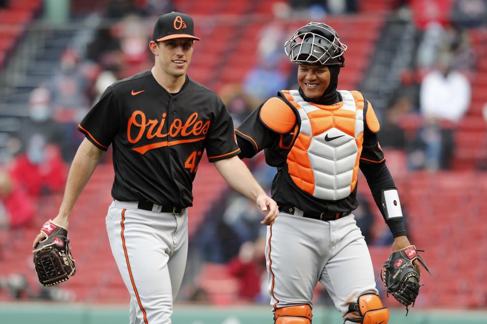 Baltimore Orioles' John Means (47) and Pedro Severino walk to the dugout after retiring the side during the seventh inning of an opening day baseball game against the Boston Red Sox, Friday, April 2, 2021, in Boston. (AP Photo/Michael Dwyer)