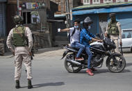 <strong>A Kashmiri man show his identity card to paramilitary soldiers during curfew in Srinagar.</strong> (AP Photo/Mukhtar Khan)<br>