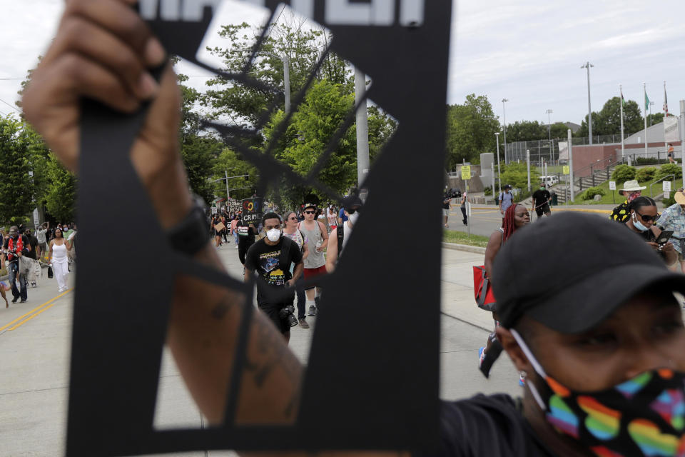 A person taking part in a Juneteenth march in Seattle holds up a stencil of a fist, Friday, June 19, 2020. Thousands of people marched to honor the Juneteenth holiday and to protest against police violence and racism. (AP Photo/Ted S. Warren)