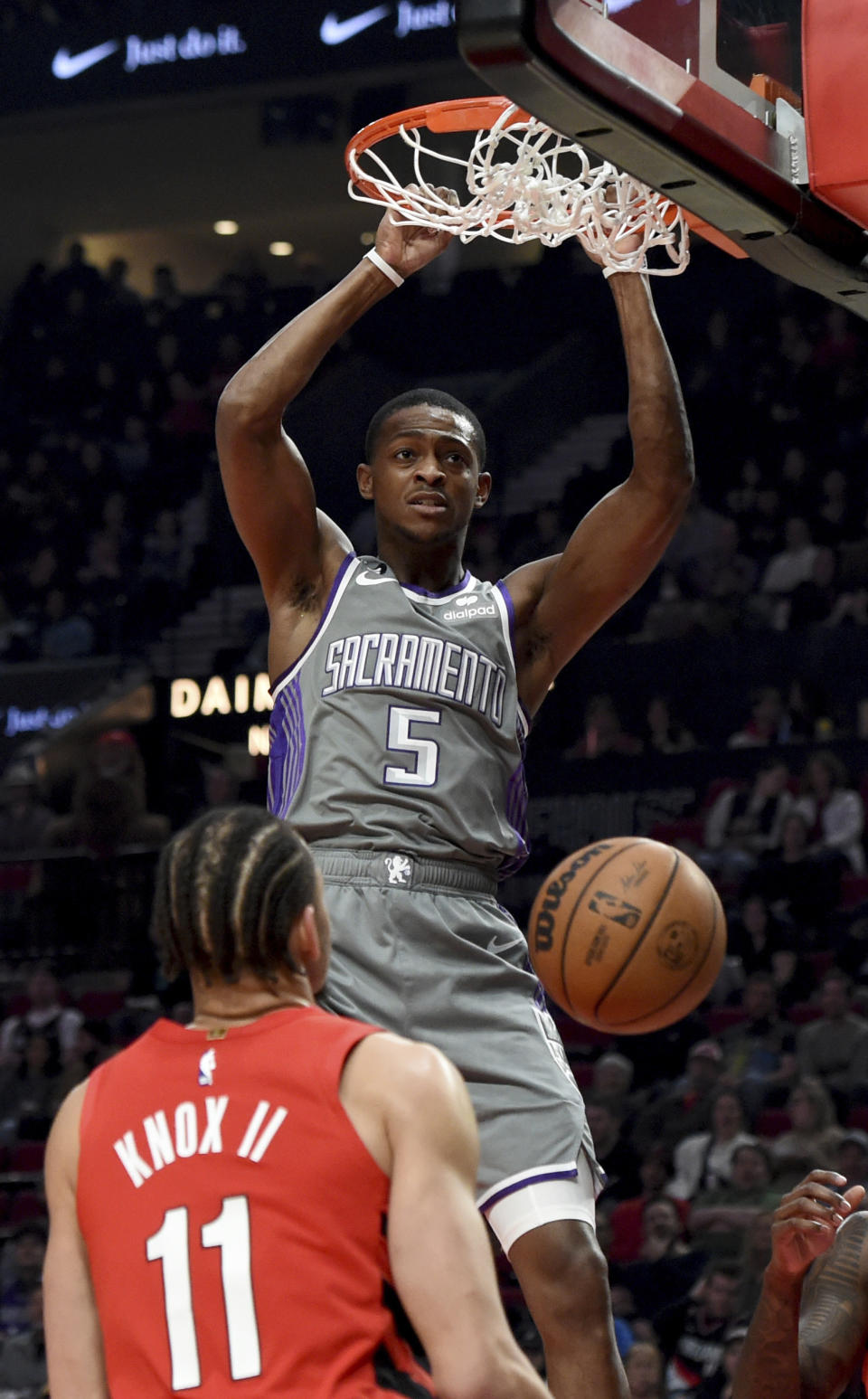 Sacramento Kings guard De'Aaron Fox, right, dunks the ball on Portland Trail Blazers forward Kevin Knox II, left, during the first half of an NBA basketball game in Portland, Ore., Wednesday, March 29, 2023. (AP Photo/Steve Dykes)