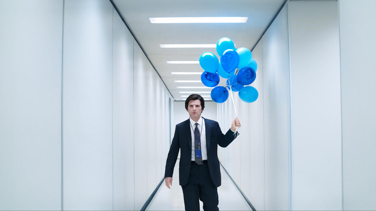  Adam Scott in Severance season 2 holding blue balloons down an ominous hallway. 