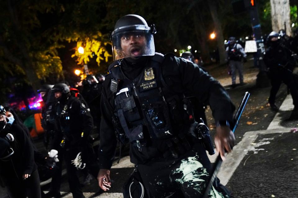 A police officer pushes back protesters Sept. 26 in Portland, Ore. The protests, which began after the death of George Floyd, have resulted in frequent clashes between protesters and law enforcement.