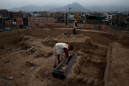 Archaeologist works at a tomb of one of sixteen Chinese migrants, discovered buried at the turn of the 20th century in the pre-colombian pyramid of Bellavista, according to Ministry of Culture, in Lima, Peru, August 24, 2017. REUTERS/Mariana Bazo