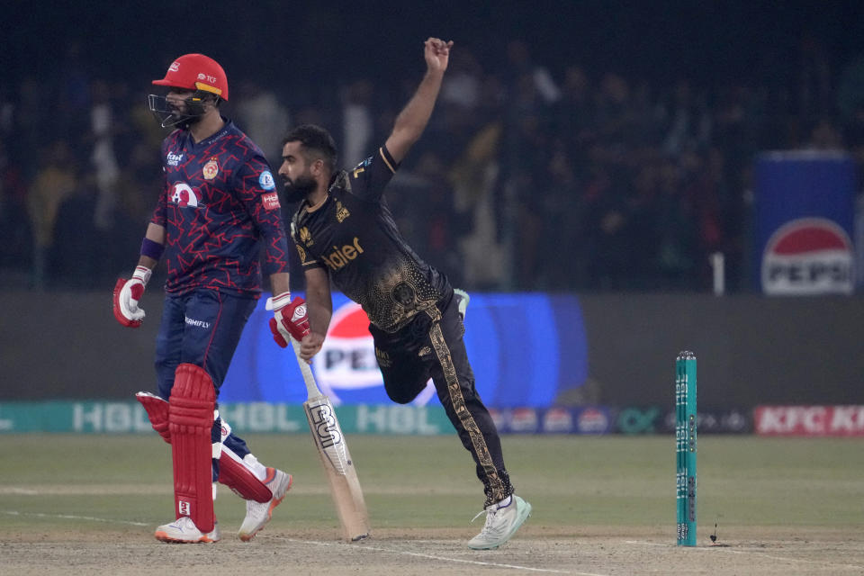 Peshawar Zalmi' Arif Yaqoob, center, bowls as Islamabad United' Imad Wasim watches during the Pakistan Super League T20 cricket match between Peshawar Zalmi and Islamabad United, in Lahore, Pakistan, Monday, Feb. 26, 2024. (AP Photo/K.M. Chaudary)