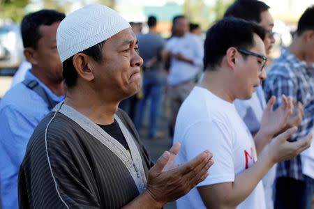 A Muslim man weeps while praying outside a mosque inside city hall compound as government forces continue their assault against insurgents from the Maute group, who have taken over large parts of Marawi City, Philippines June 25, 2017. REUTERS/Jorge Silva