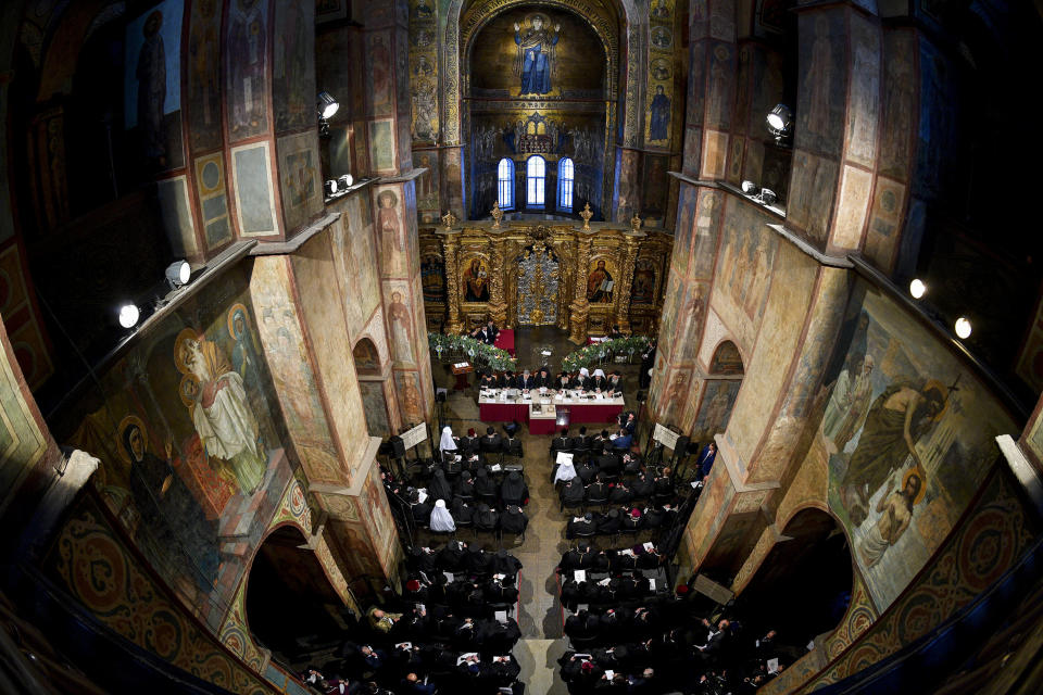 Ukrainian President Petro Poroshenko, background third left, attends a closed-door synod of three Ukrainian Orthodox churches to approve the charter for a unified church and to elect leadership in the St. Sophia Cathedral in Kiev, Ukraine, Saturday, Dec. 15, 2018. Ukrainian Orthodox leaders on Saturday approved the creation of a unified church independent of the Moscow Patriarchate and elected a leader to head the new church, officials said. The leader of the new autocephalous Ukrainian Orthodox Church will be Metropolitan Epiphanius, a 39-year old bishop from the Kiev Patriarchate. (Mykola Lazarenko, Ukrainian Presidential Press Service/Pool Photo via AP)