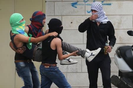 A wounded Palestinian protester is evacuated by comrades during clashes near the Jewish settlement of Bet El, near the West Bank city of Ramallah October 23, 2015. REUTERS/Mohamad Torokman