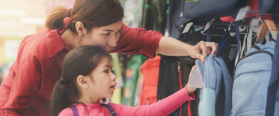 Back to school concept, Young asian mother or parent and little girl kid  buying school satchel or bag in store, Selective focus