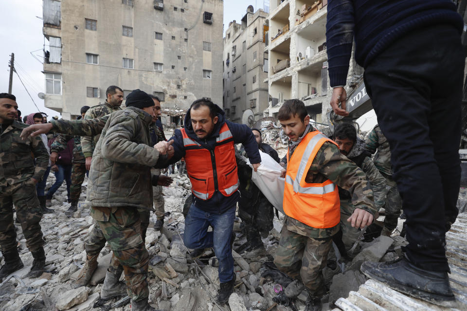 FILE - Rescue teams carry the body of a victim from a destroyed building after a devastating earthquake rocked Syria and Turkey, in Aleppo, Syria, Tuesday, Feb. 7, 2023. For years, the people of Aleppo bore the brunt of bombardment and fighting when their city, once Syria's largest and most cosmopolitan, was one of the civil war's fiercest battle zones. Even that didn't prepare them for the new devastation and terror wreaked by this week's earthquake. (AP Photo/Omar Sanadiki, File)