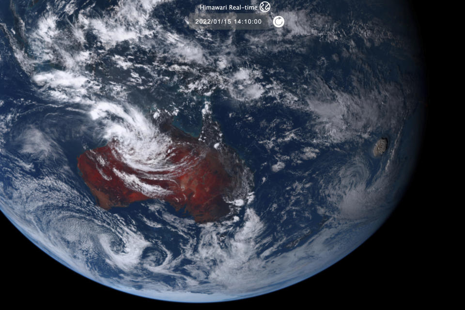 This satellite image taken by Himawari-8, a Japanese weather satellite operated by Japan Meteorological Agency and released by National Institute of Information and Communications Technology (NICT), shows an undersea volcano eruption, right, at the Pacific nation of Tonga Saturday, Jan. 15, 2022. (NICT via AP)