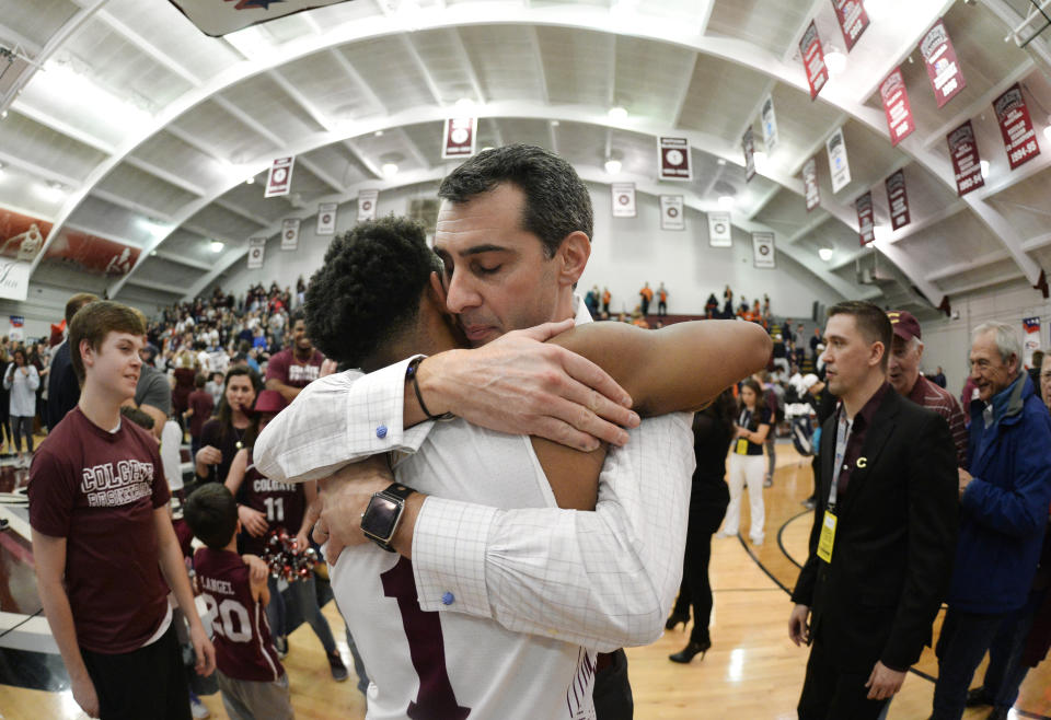 Colgate coach Matt Langel hugs guard Jordan Burns after the team's win against Bucknell in an NCAA college basketball game for the championship of the Patriot League men's tournament in Hamilton, N.Y., Wednesday, March 13, 2019. Colgate won 94-80. (AP Photo/Adrian Kraus)