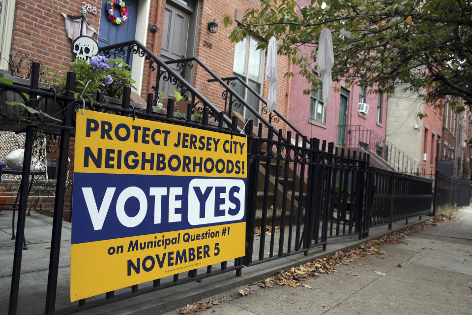 A sign urging people to vote on municipal question #1 is displayed in Jersey City, N.J., Tuesday, Nov. 5, 2019. Residents of New Jersey's second-largest city will decide Tuesday whether its increasing popularity as an affordable short-term rental option across the river from New York City has reached the point where restrictions are needed to rein in some of the unwanted byproducts.(AP Photo/Seth Wenig)