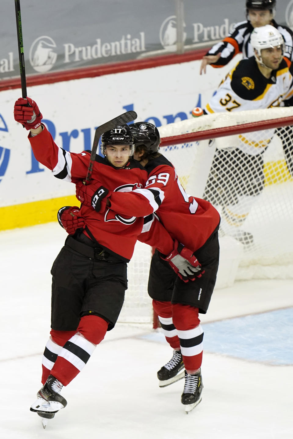 New Jersey Devils center Yegor Sharangovich (17) celebrates with Devils left wing Janne Kuokkanen (59) after scoring a game-tying goal during the third period of an NHL hockey game against the Boston Bruins, Tuesday, May 4, 2021, in Newark, N.J. (AP Photo/Kathy Willens)