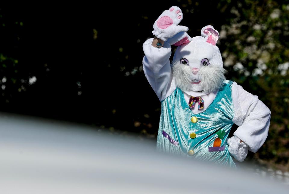 The Easter Bunny, Tiffany Procter, waves at passing motorists on April 10, 2020.