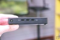 <p>The Microsoft Adaptive Hub held in mid-air with its side edge in view, showing three USB-C ports and a switch button.</p> 