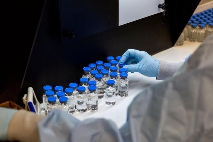 A lab technician inspects filled vials of investigational remdesivir at a Gilead Sciences facility in La Verne