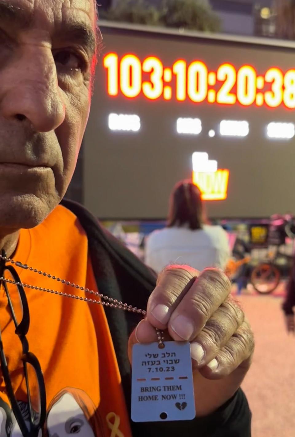 Eli Bibas, whose son's entire family was taken by Hamas, including 4-year-old Ariel and 1-year-old Kfir, stands in front of a clock in Tel Aviv's Hostage Square marking how long the kidnapped have been gone.