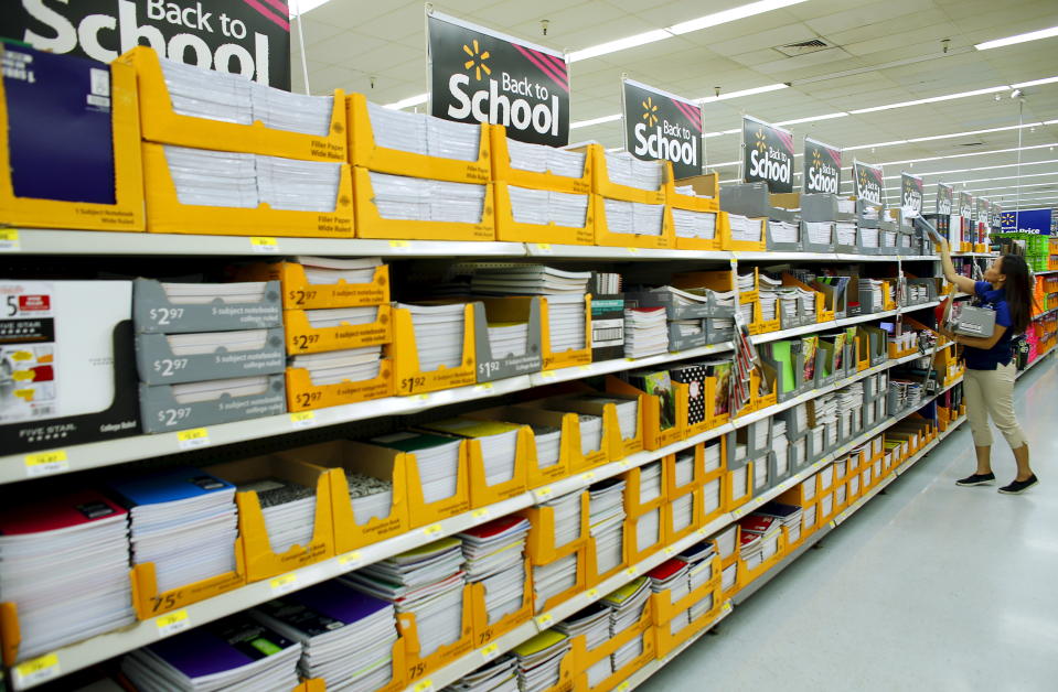 Walmart department manager Karren Gomes helps stock shelves with school supplies as the retail store prepare for back to school shoppers in San Diego, California August 6, 2015.      REUTERS/Mike Blake