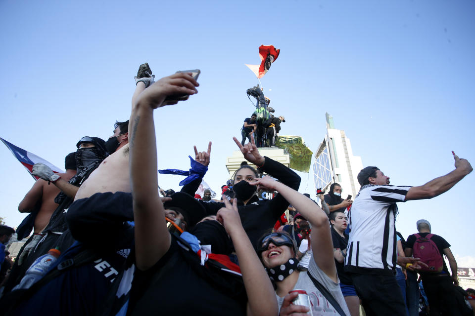 Manifestantes contra el gobierno se reúnen en la Plaza Italia tras un plebiscito para decidir si el país debe reemplazar su constitución de hace 40 años, redactada durante la última dictadura militar, en Santiago, Chile, el domingo 25 de octubre de 2020. (AP Foto/Luis Hidalgo)