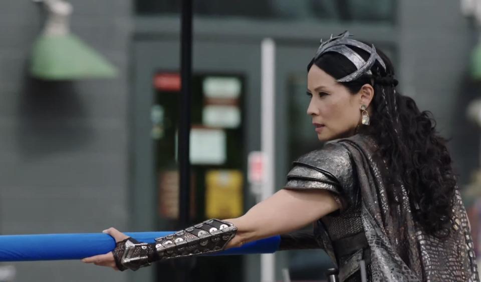 Lucy Liu in Shazam! Fury of the Gods holding a blue-screen weapon