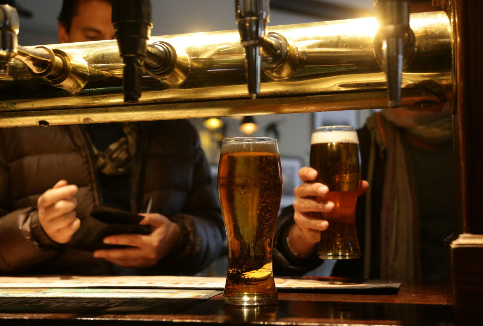 Customers collecting their drinks at the bar of Irish pub O'Neill's in Carnaby Street, central London. 