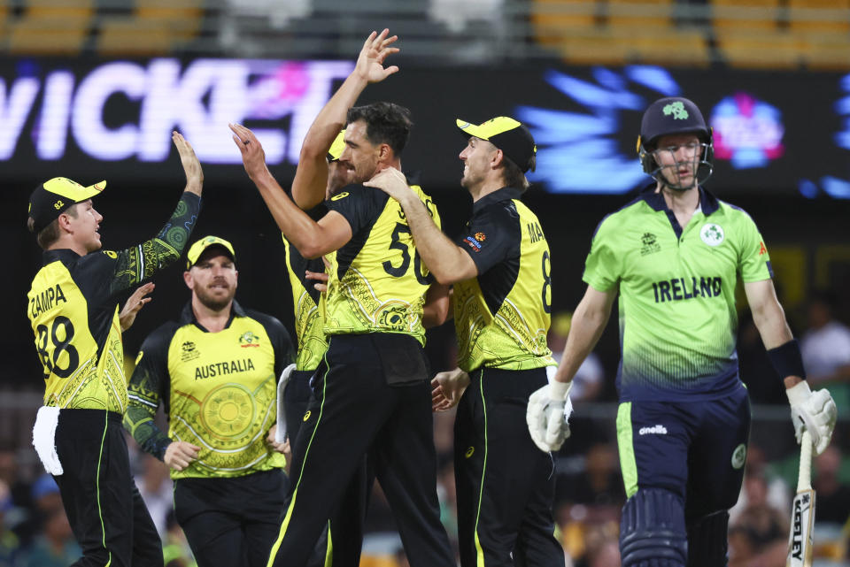 Australia's Mitchell Starc is congratulated by teammates after dismissing Ireland's George Dockrell, right, during the T20 World Cup cricket match between Australia and Ireland, in Brisbane Australia, Monday, Oct. 31, 2022. (AP Photo/Tertius Pickard)