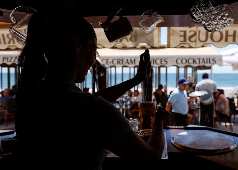 FILE PHOTO: A waitress pours beer in a restaurant in Playa del Ingles, Maspalomas on the island of Gran Canaria
