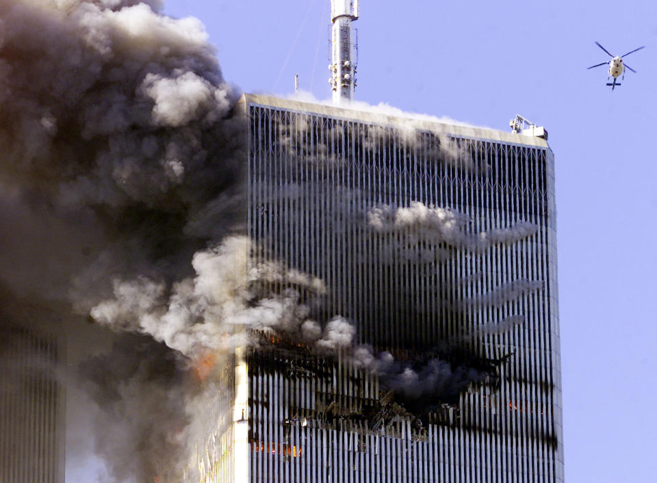 The World Trade Center in New York City burns as a police helicopter flies nearby early September 11, 2001. (Jeff Christensen/Reuters)
