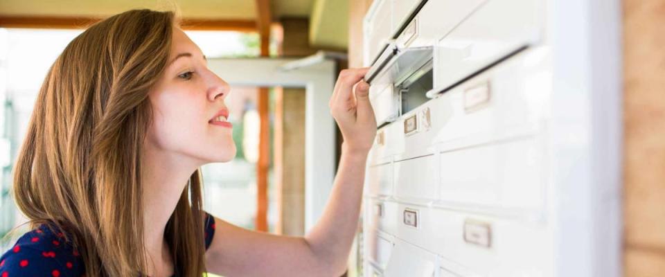 Young woman checking her mailbox for new letters