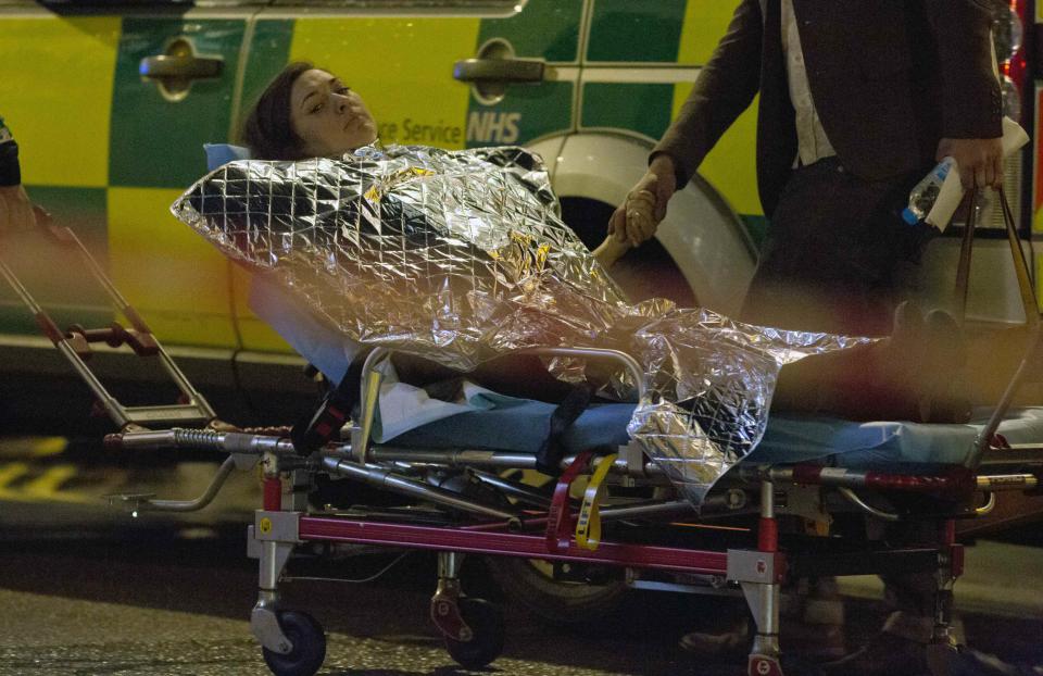 A woman receives medical attention after part of the ceiling at the Apollo Theatre on Shaftesbury Avenue collapsed in central London