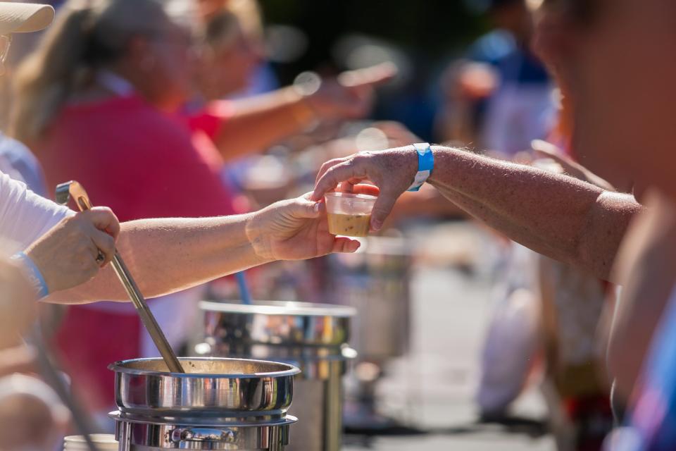 A volunteer hands a guest a sample of shrimp chowder at a 2022 Empty Bowls event in Delray Beach. The national grassroots effort visits Palm Beach Gardens Sept. 30.