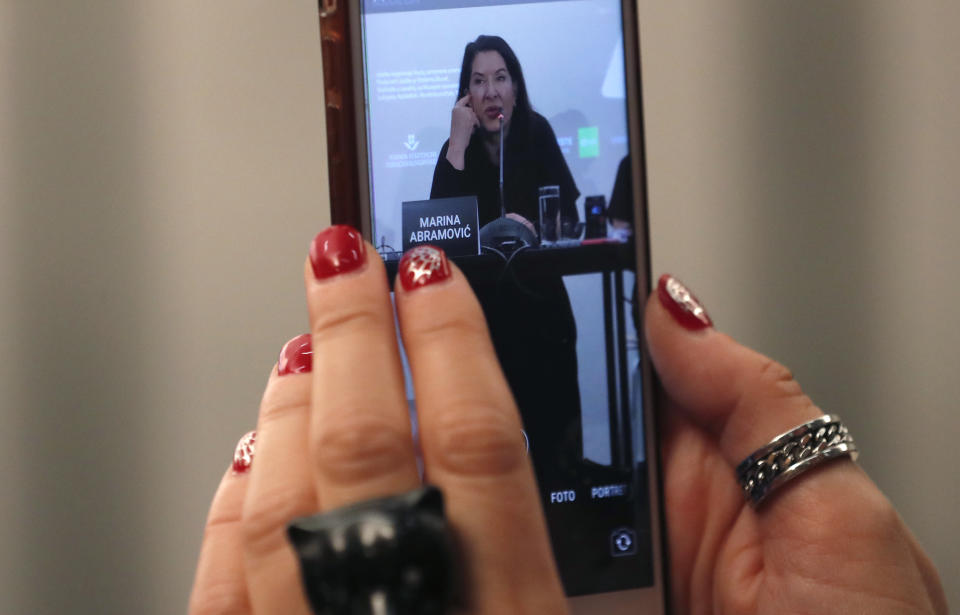 A journalist takes a photo with his phone during the press conference of performance artist Marina Abramovic, for the art exhibition "Marina Abramovic - The Cleaner" in the Museum of Contemporary Art in Belgrade, Serbia, Saturday, Sept. 21, 2019. Abramovic is displaying her work in her native Belgrade for the first time in 44 years and she says that returning home has been highly emotional. (AP Photo/Darko Vojinovic)