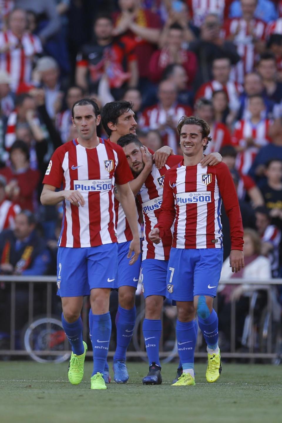 Atletico Madrid's Jorge Resurreción "Koke", second right, celebrates with teammates Antoine Griezmann, right, Diego Godin, left, and Stefan Savic after scoring their side's third goal against Sevilla during a La Liga soccer match between Atletico Madrid and Sevilla at the Vicente Calderon stadium in Madrid, Sunday, March 19, 2017. Koke, Griezmann and Godin scored once each in Atletico's 3-1 victory. (AP Photo/Francisco Seco)