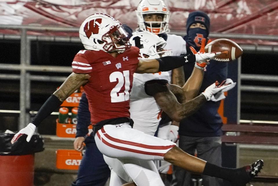 Illinois punter Blake Hayes catches a pass with Wisconsin cornerback Caesar Williams defending during the second half of an NCAA college football game Friday, Oct. 23, 2020, in Madison, Wis. Wisconsin won 45-7. (AP Photo/Morry Gash)