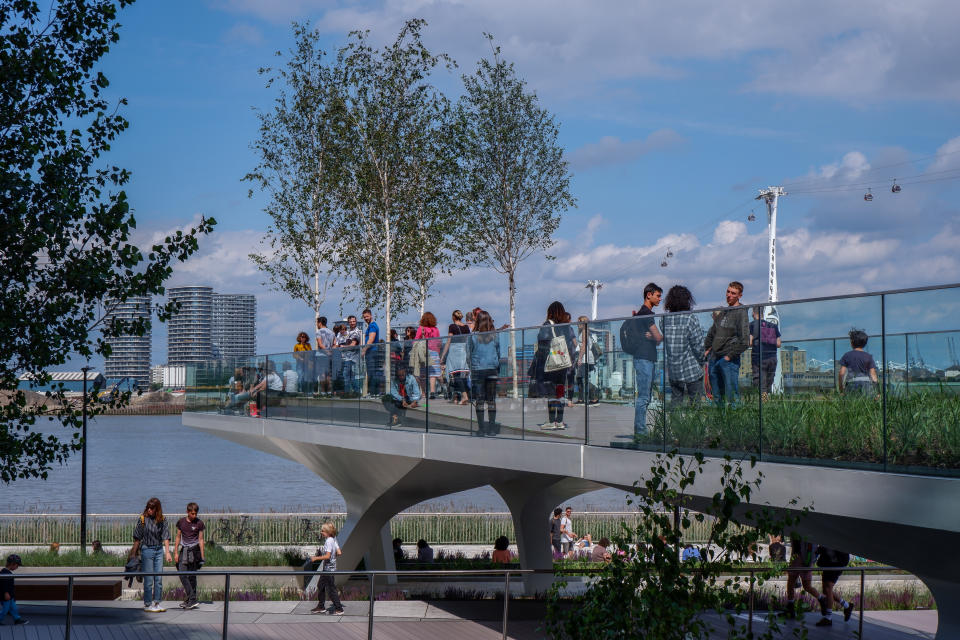 People walking 'The Tide' bridges . The Tide is a linear park with elevated walks around the Greenwich Peninsula South London England UK