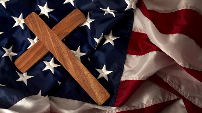 A cross lies on an American flag.