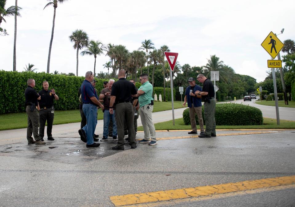 People including members of the Florida Department of Transportation, the Palm Beach County Sheriff's Office and the U.S. Secret Service gather outside of former President Donald Trump's Mar-a-Lago Club near the roundabout at the east end of Southern Boulevard on the morning of July 19. The roundabout will serve as the southern point of an indefinite closure that will extend north along South Ocean Boulevard to South County Road, the Florida Department of Transportation said Friday.
