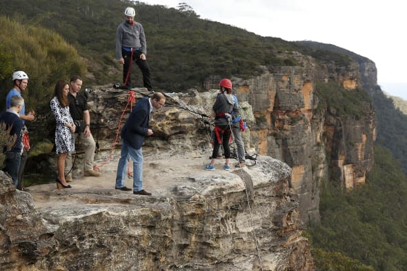 The Duke of Cambridge (centre) looks over the edge of a cliff as he and the Duchess of Cambridge visit the Narrow Neck Lookout and observes abseiling by the Mountain Youth Services group in the Blue Mountains town of Katoomba, west of Sydney. PRESS ASSOCIATION Photo. Picture date: Thursday April 17, 2014. See PA story ROYAL Tour. Photo credit should read: Phil Noble/PA Wire