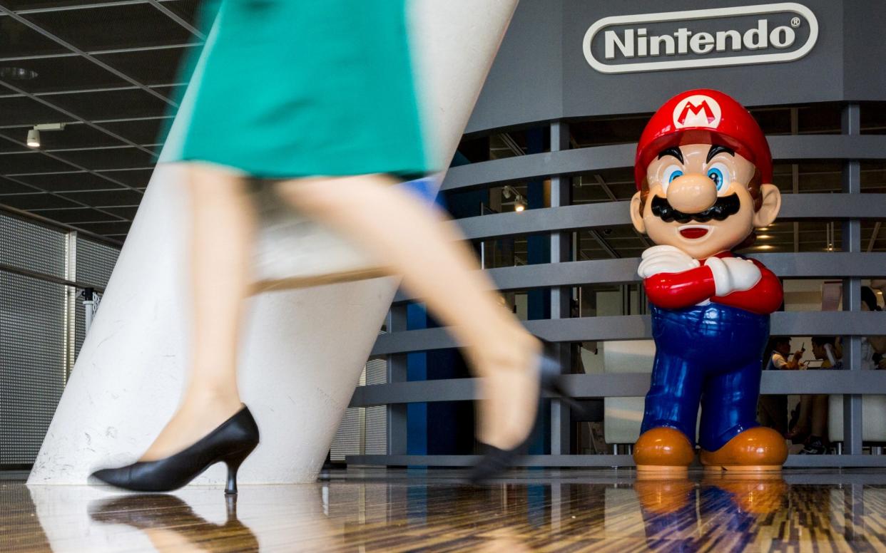 A woman walks past a figure of "Mario", a character in Nintendo's "Mario Bros." video games, at a Nintendo centre in Tokyo, Japan -  Thomas Peter/REUTERS