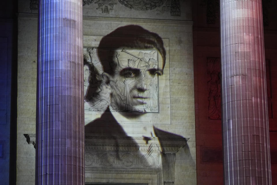 The portrait of Missak Manouchian is projected on the facade of Pantheon monument, Wednesday, Feb. 21, 2024 in Paris. While France hosts grandiose ceremonies commemorating D-Day, Missak Manouchian and his Resistance fighters' heroic role in World War II are often overlooked. French President Emmanuel Macron is seeking to change that by inducting Manouchian into the Panthéon national monument. (AP Photo/Michel Euler)