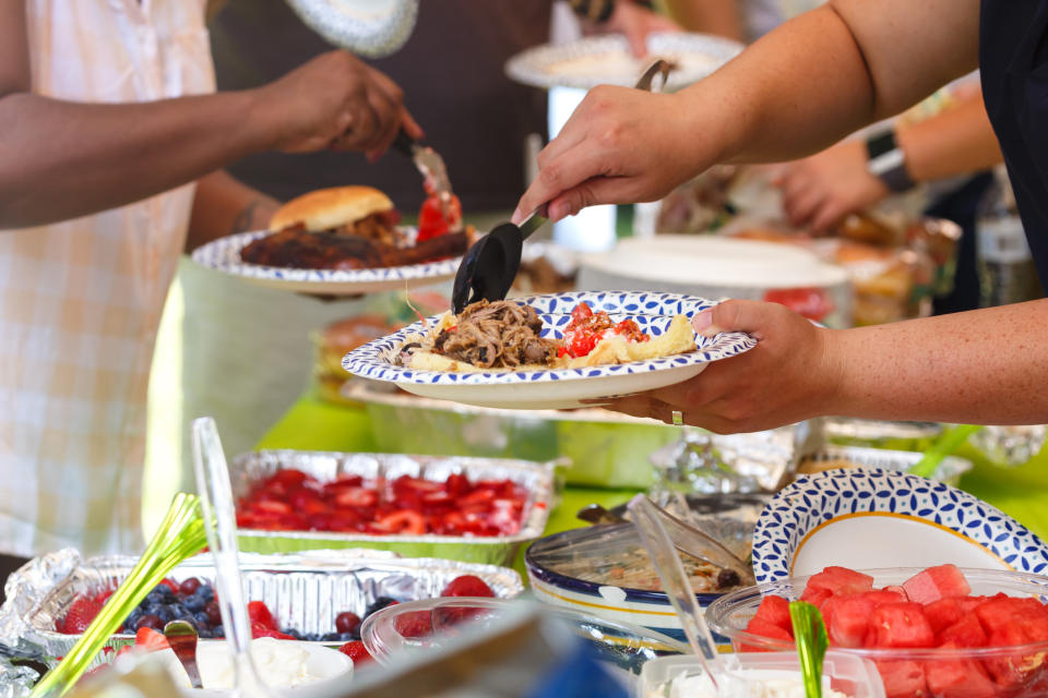 People putting food on their plates at a potluck