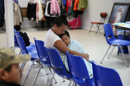 FILE PHOTO: An undocumented Honduran immigrant and her son, recently released from detention through "catch and release" immigration policy, pass time at the Catholic Charities relief center in McAllen, Texas, U.S., April 14, 2018. REUTERS/Loren Elliott/File Photo