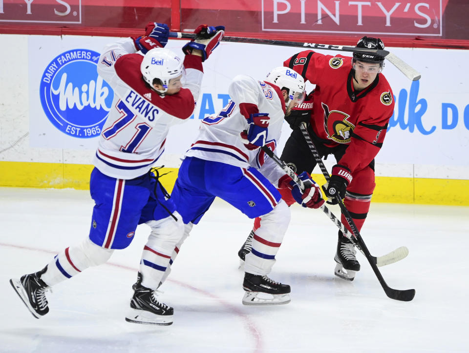 Ottawa Senators' Josh Norris (9) looks for a pass as Montreal Canadiens' Jake Evans (71) and Victor Mete (53) defend during the second period of an NHL hockey game Thursday, April 1, 2021, in Ottawa, Ontario. (Sean Kilpatrick/The Canadian Press via AP)