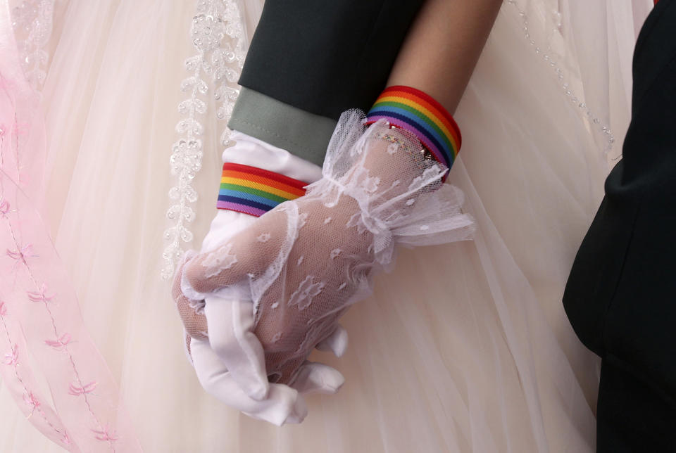 Lesbian couples Chen Ying-hsuan, right, holds Li Li-chen's hand during a military mass weddings ceremony in Taoyuan city, northern Taiwan, Friday, Oct. 30, 2020. Two lesbian couples tied the knot in a mass ceremony held by Taiwan's military on Friday in a historic step for the island. Taiwan is the only place in Asia to have legalized gay marriage, passing legislation in this regard in May 2019. (AP Photo/Chiang Ying-ying)