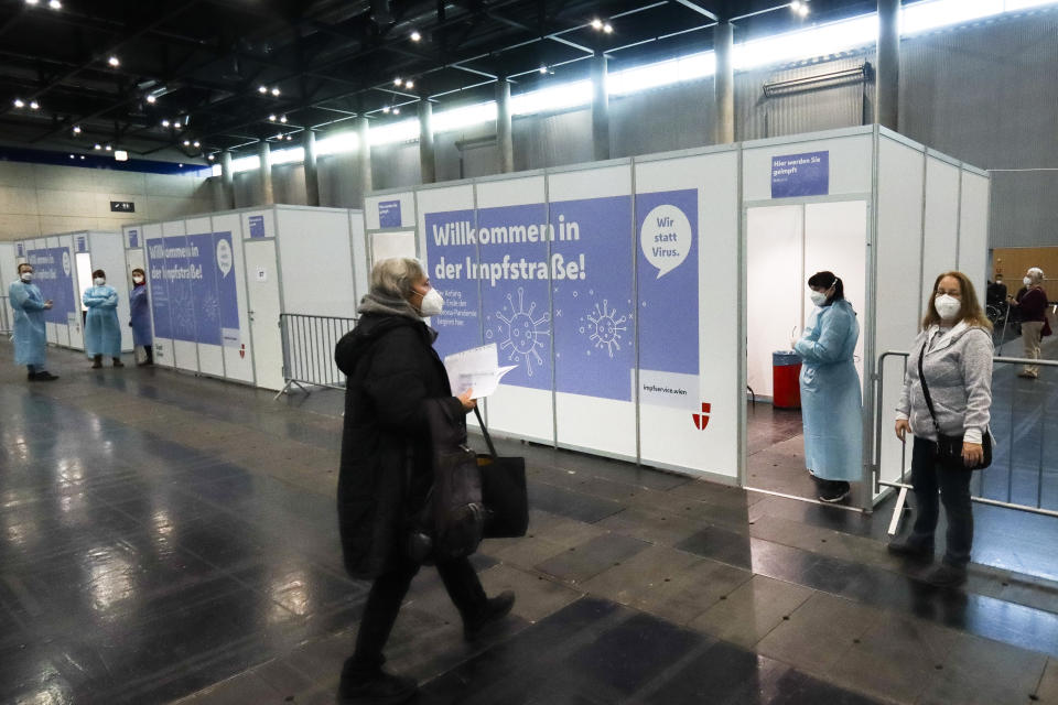 A Holocaust survivor, left, arrives to get a shot of the Pfizer/BioNTech vaccine against the COVID-19 disease, at a vaccination center on International Holocaust Remembrance Day in Vienna, Austria, Wednesday, Jan. 27, 2021. Hundreds of Holocaust survivors in Austria and Slovakia were poised to get their first coronavirus vaccinations on Wednesday to acknowledge their past suffering with a special tribute 76 years after the liberation of the Auschwitz death camp, where the Nazis killed more than 1 million Jews and others. The vaccinations were also offered to all other Jews in the area older than 85. (AP Photo/Ronald Zak)